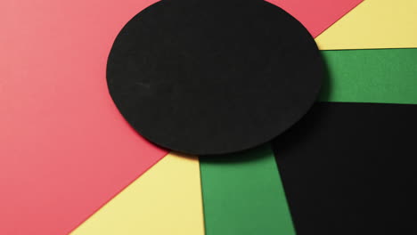 Video-of-red,-yellow-and-green-papers-with-copy-space-on-black-background