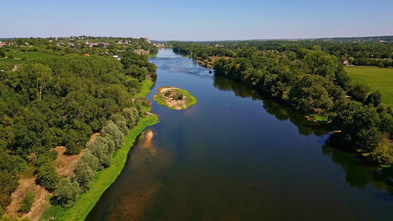 Forward drone fly over the calm Vienne River with green riverbanks near Chinon, Indre-et-Loire, France