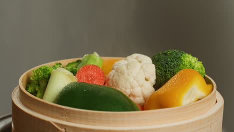 steaming colorful vegetables in a bamboo steamer