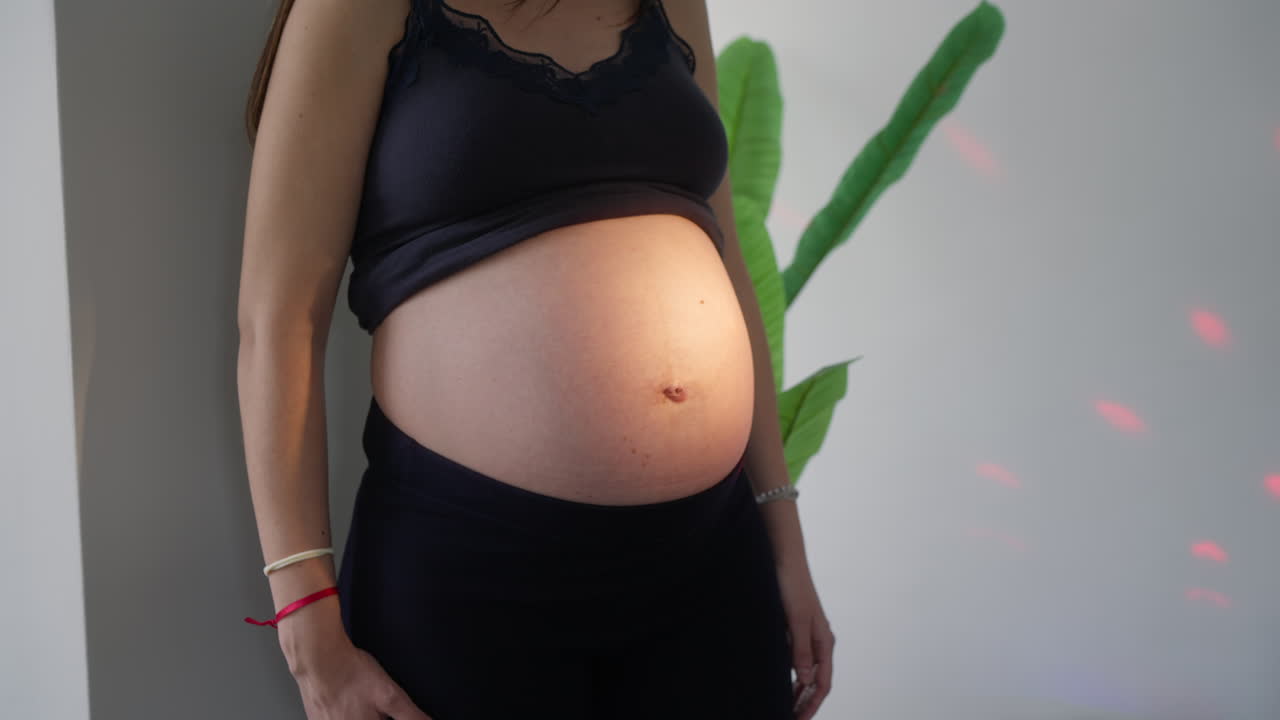 Pregnant Woman's Belly Illuminated by Colored Lights