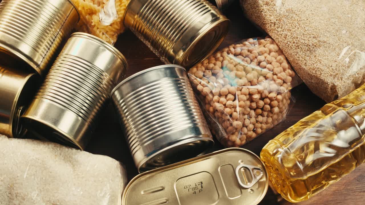 Canned cereals beans fish and vegetables, an assortment of processed foods, supermarket cart online shopping, delivery.