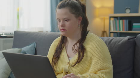 girl with down syndrome video calling on laptop