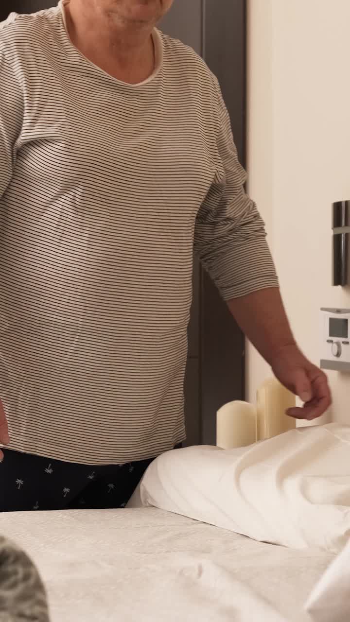 Gay couple finishing making bed together in the morning