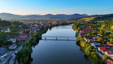 flight over the river approaching the bridge over it. lovely rural area located on the banks of the river at sunset. countryside in slovakia.