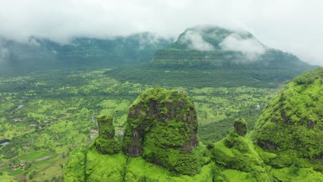 over a peak as the clouds pass by on a monsoon afternoon over the rich green surroundings