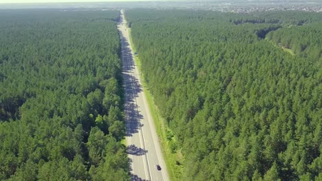 Aerial-Flying-back-over-the-highway-located-in-dense-forest