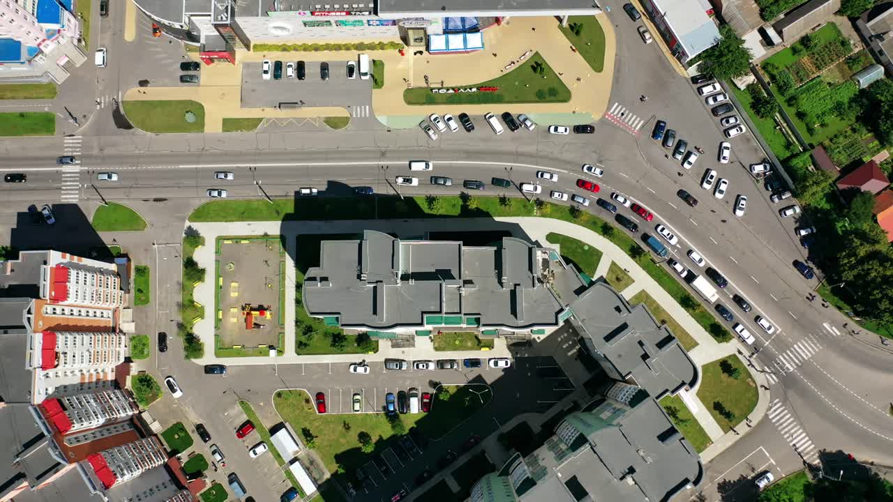 Modern city. Urban district with architecture and road filled with moving cars. View from above. Motion camera top down.