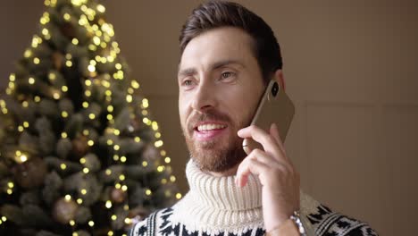 feliz joven sonriente charlando por teléfono celular con amigos en la víspera de navidad