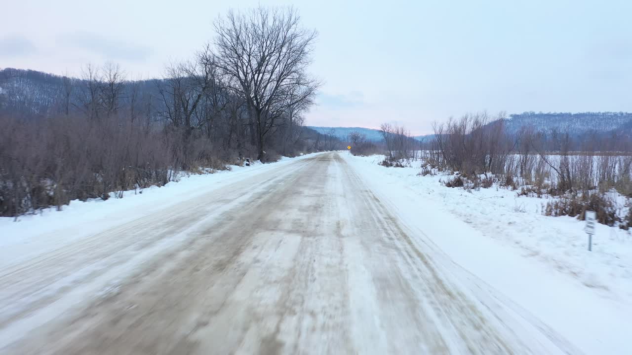 겨울 숲 을 가로지르는 눈 인 시골 도로