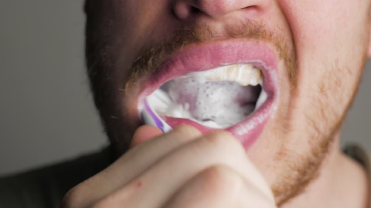 Primo piano: uomo adulto che si spazzola i denti