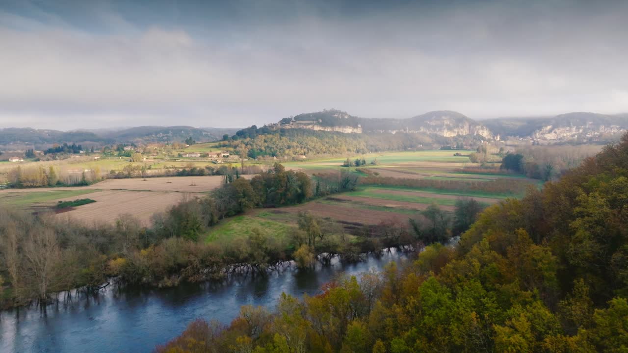 Drohnenaufnahme im Nebel über dem Fluss, Ankunft im Dorf La Roque Gageac und den Gärten von Marqueyssac in der Dordogne, nahe Sarlat La Caneda, Frankreich.