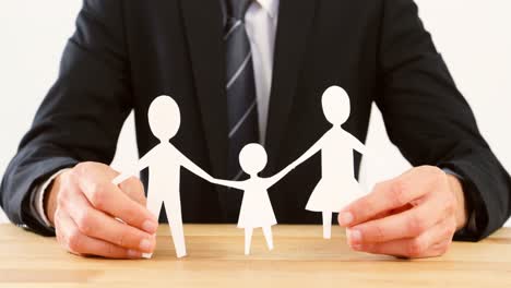 businessman holding a paper cut out of family