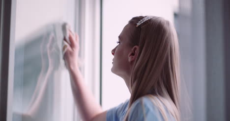 mujer de limpieza limpiando ventanas con detergentes 3