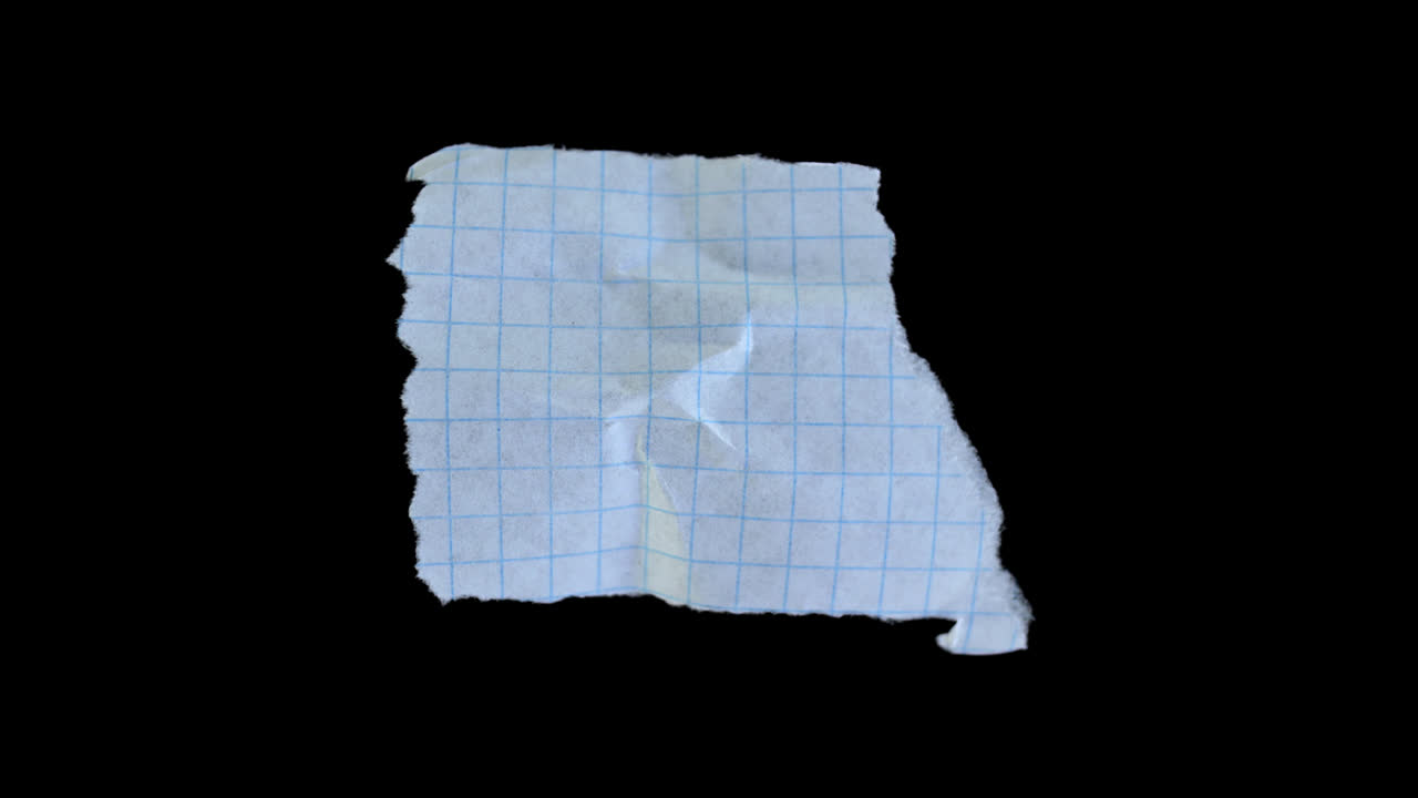 Skrynkligt rutat papper som vecklas ut på svart bakgrund