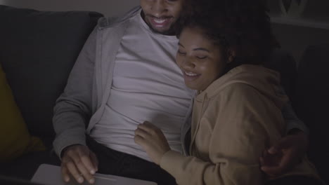 young couple choosing a film to watch on the laptop