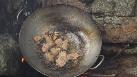 cocina asiática tradicional, chef friendo carne en estufa de piedra en wok