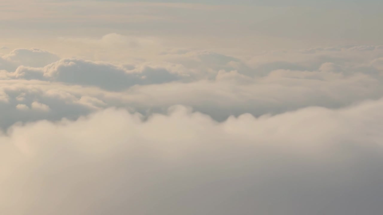 Kamera drone menggeser memperlihatkan puncak awan membulat di atas cakrawala pucat untuk menunjukkan gumpalan awan di latar depan