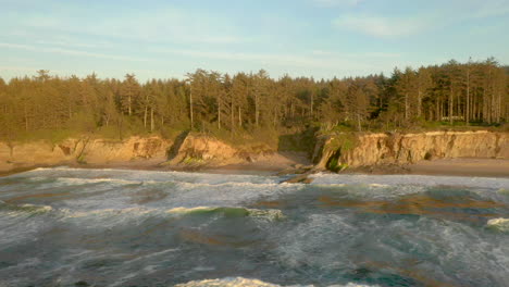 drone flying sideways over ocean near yoakam point at the oregon coast