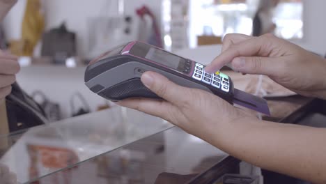 shop cashier inserting credit card in pos terminal