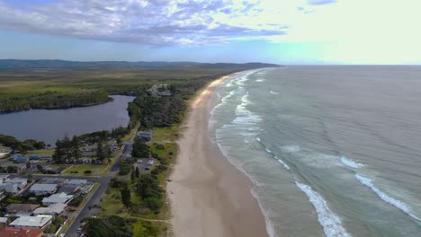 Lake-Ainsworth-By-The-Seaside-In-Lennox-Head---Fresh-Water-Lagoon-Infused-With-Tannins-Of-Surrounding-Tea-Trees---NSW,-Australia---aerial-drone