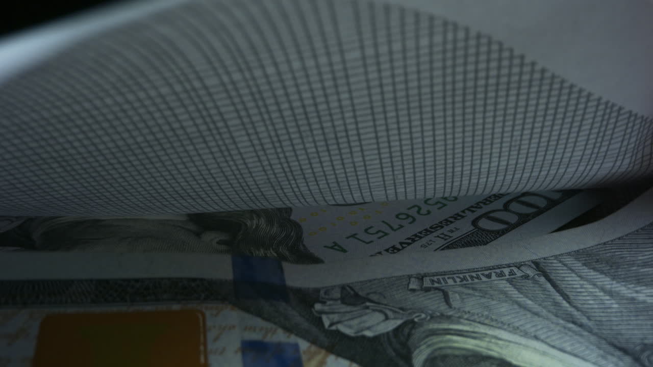 100달러 지폐 를 봉투 에 넣고 있는 사업가 의 손