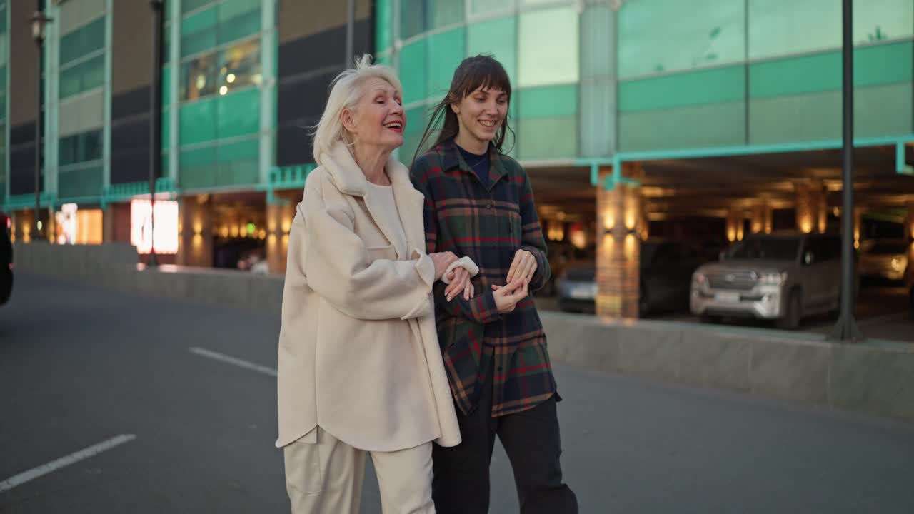 Older and younger woman walking together in city