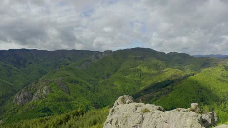 aerial approaching shot of green covered mountains during cloudy day in bulgaria, belintash plateau, rhodope mountain