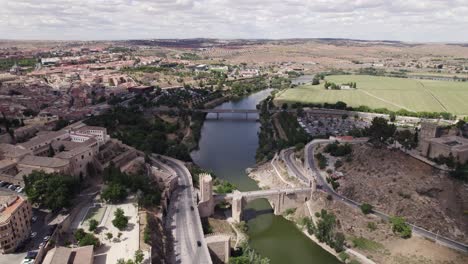 aerial view of roman arch bridge spanning mirror-like river tagus