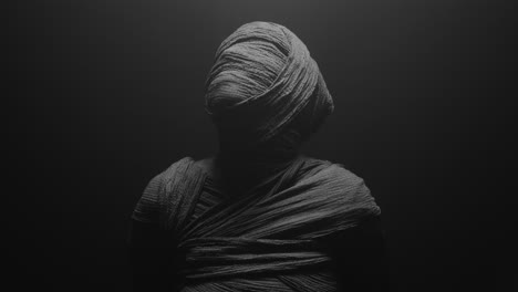 a mummy of a woman on a dark backdrop turns and then lowers her head