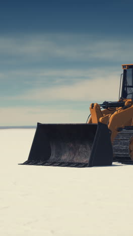 yellow bulldozer in a snowy desert