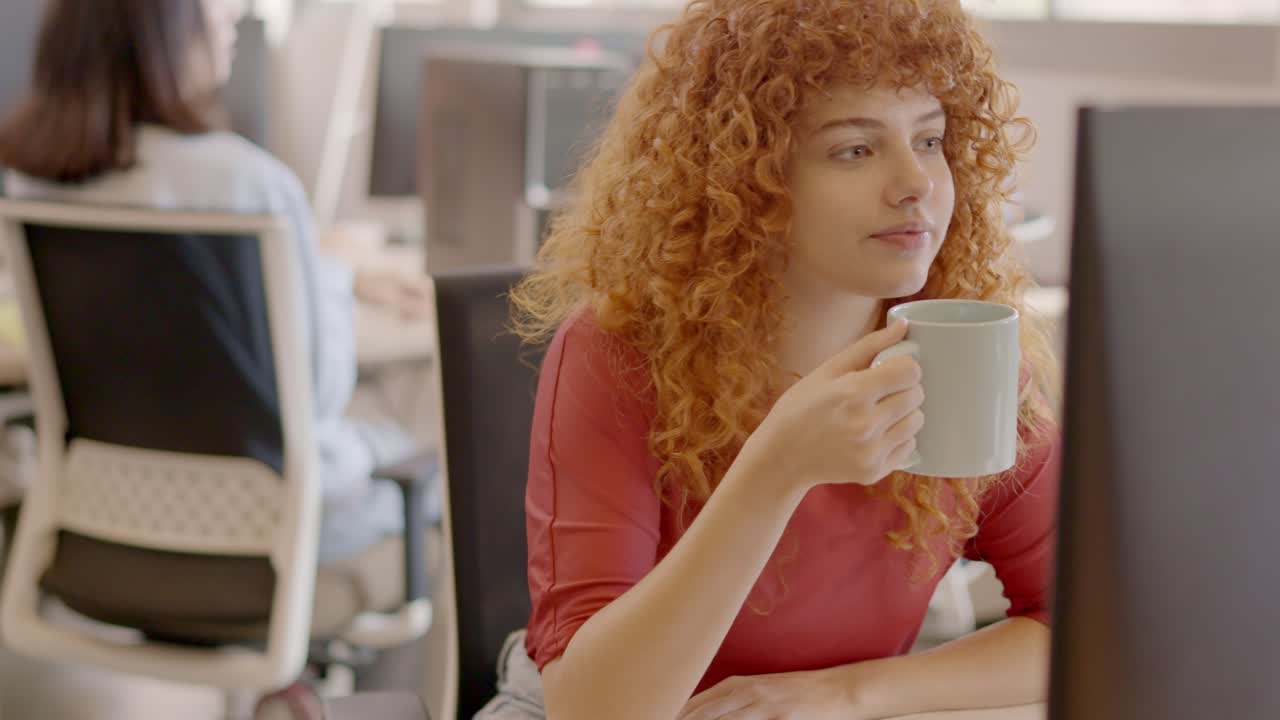 Woman working with computer and smiling in a coworking