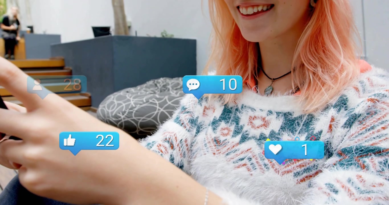 Woman sitting on deck tapping smartphone as moving social media icons popping up showing engagement