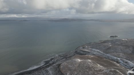 Vista-Del-Acantilado-Del-Viejo-De-Storr-En-La-Isla-De-Skye,-Escocia,-Con-Cielos-Nublados-Y-Mar-Sereno.