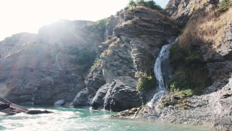 Sie-Schweben-Flussabwärts-Von-Einem-Wasserfall-Im-Historischen-Skippers-Canyon,-Umgeben-Von-Hoch-Aufragenden,-Schroffen-Klippen