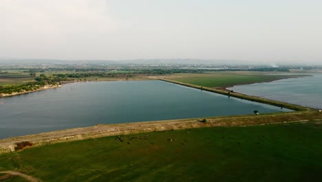 Aerial-view-shot-of-Landscape-at-the-end-of-Pa-Sak-Jolasid-Dam-with-green-grass-and-water