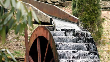 el agua fluye en cámara lenta sobre la vieja rueda de agua disparada a 180 fotogramas por segundo