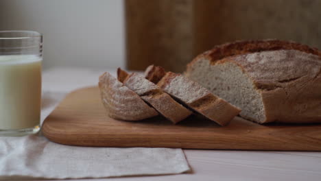 slice bread on cutting board. baked product. milk glass on table. bakery food