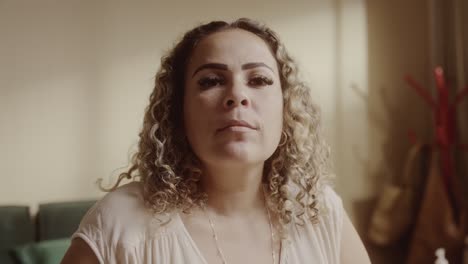 portrait of a woman with curly hair looking at camera