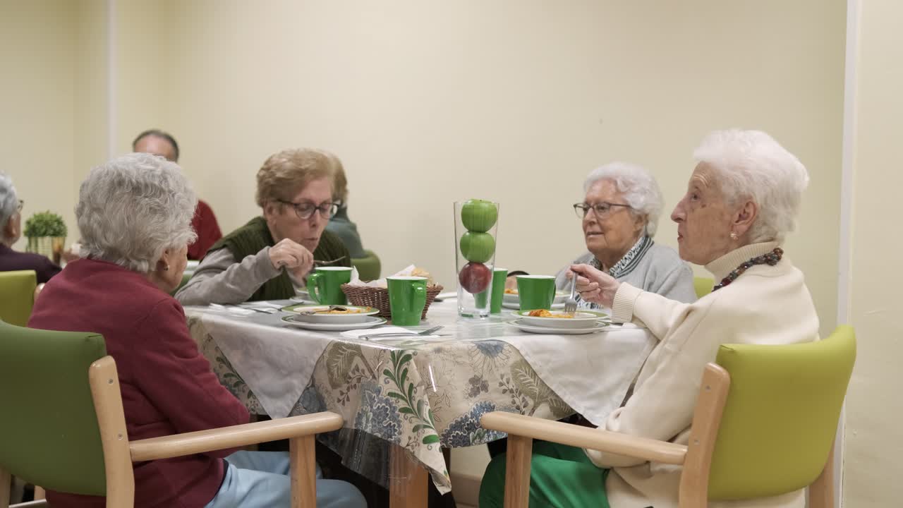 Senior women eating food during dinner in retirement home