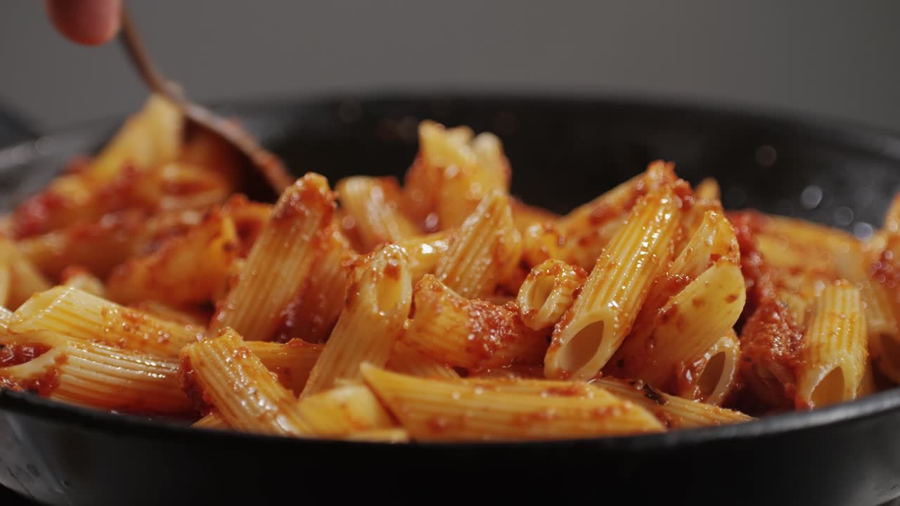 Cooking traditional arrabbiata pasta, penne with tomato sauce close-up. Cook classic homemade Italian tomato sauce for pasta and pizza in the pan. Chef cooks traditional Italian food. High quality 4k footage
