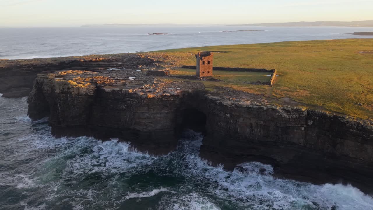 Havbølger der slår mod de barske klipper ved Mutton Island kysten i den gyldne time.