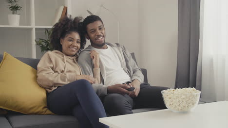 young couple having fun while watching tv