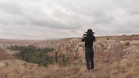 zoom en vista joven turista caucásica mujer en ropa inteligente con teléfono inteligente de mano capturar vacaciones naturaleza