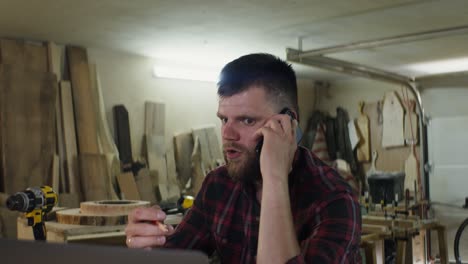 angry carpenter on phone in workshop