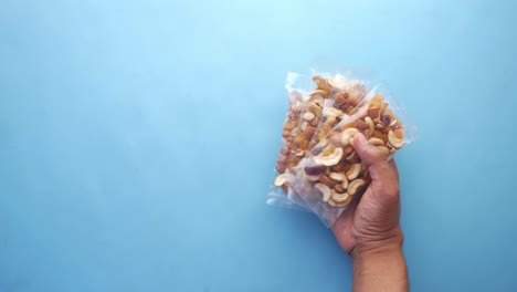 hand holding a bag of mixed nuts and dried fruit