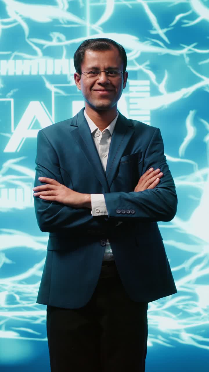 Vertical video Smiling technician in startup stands with arms crossed, exuding professionalism