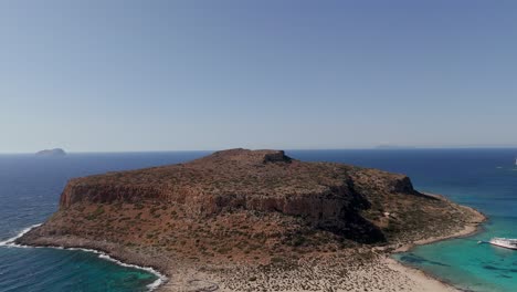 aerial - rugged rocky island and blue sea at balos lagoon, crete, greece