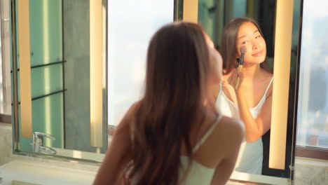 결점 없는 피부를 가진 아름다운 젊은 여성이 홍당무로 화장을 한다