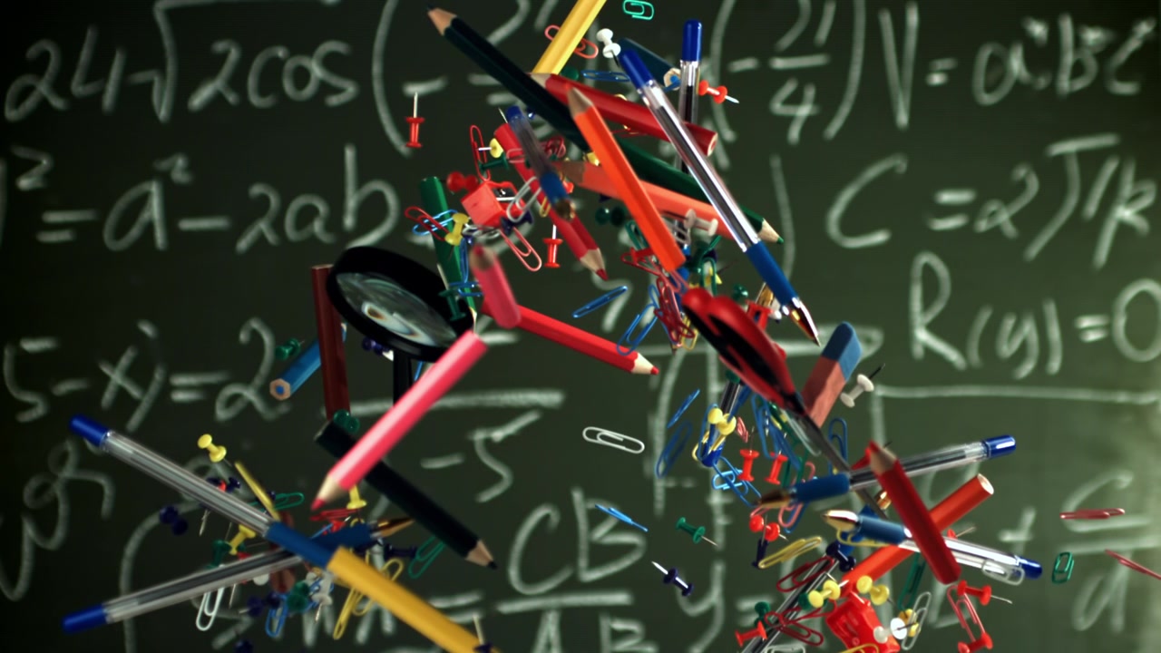Colorful School and Office Supplies Floating in Slow Motion Against a Math Blackboard