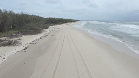 Eine-Frau-Im-Badeanzug,-Die-Auf-Der-Sandigen-Küste-In-North-Stradbroke-Island,-Moreton-Bay,-Queensland,-Australien,-Spazieren-Geht